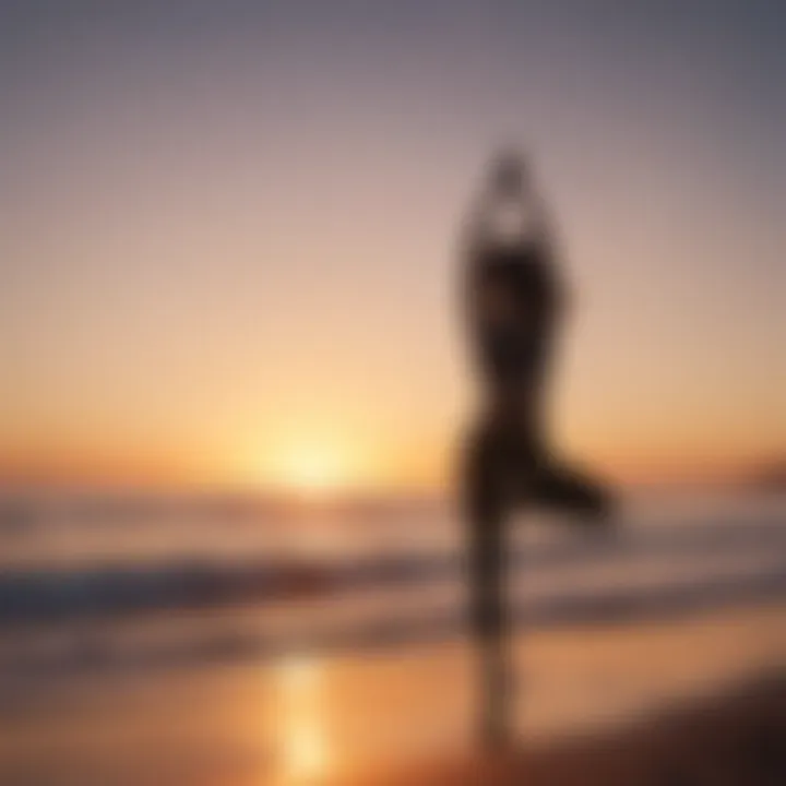 Silhouette of a person practicing yoga on a serene beach at sunrise